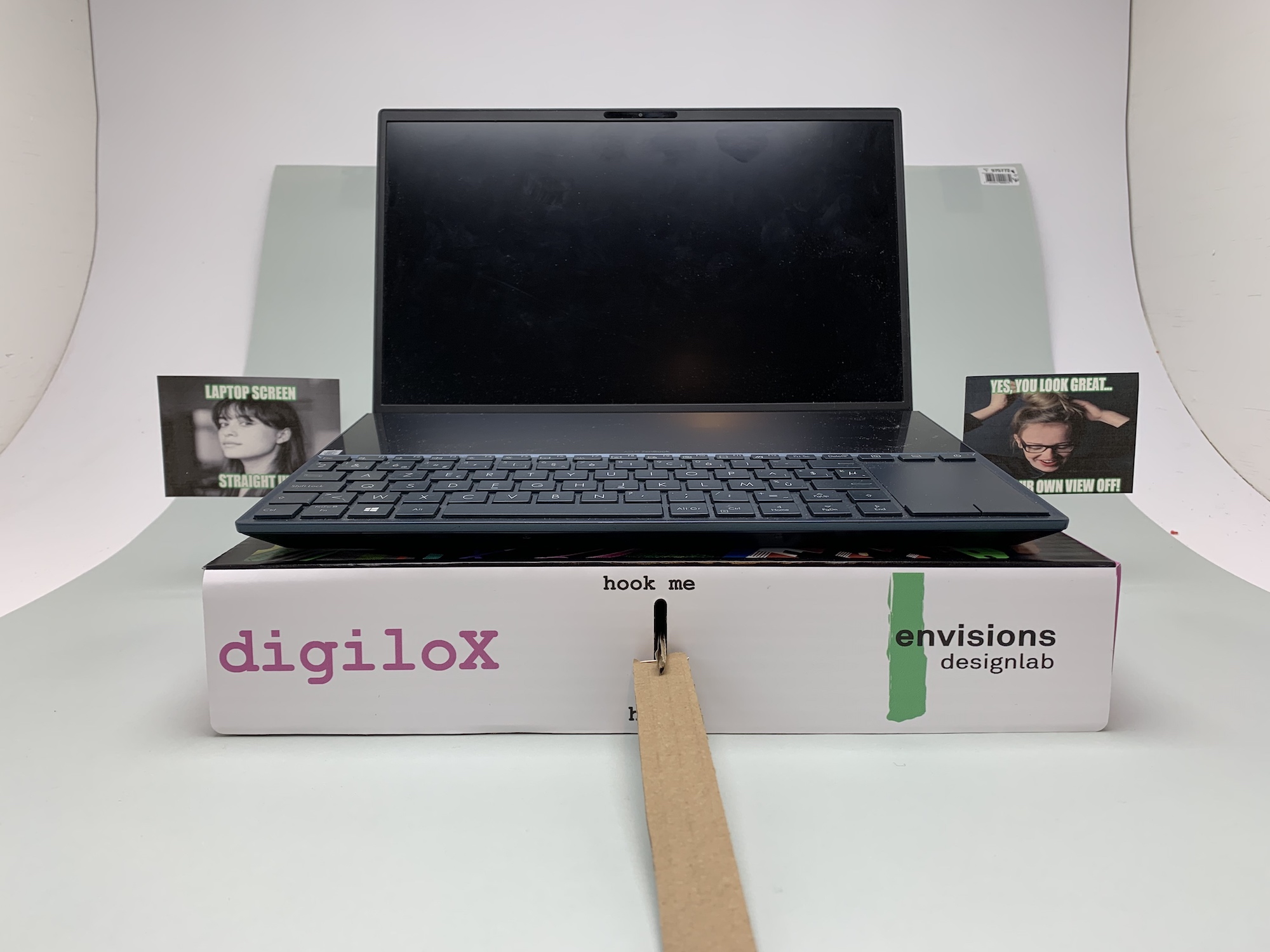 A laptop sitting on the box with one of the cards on each side.